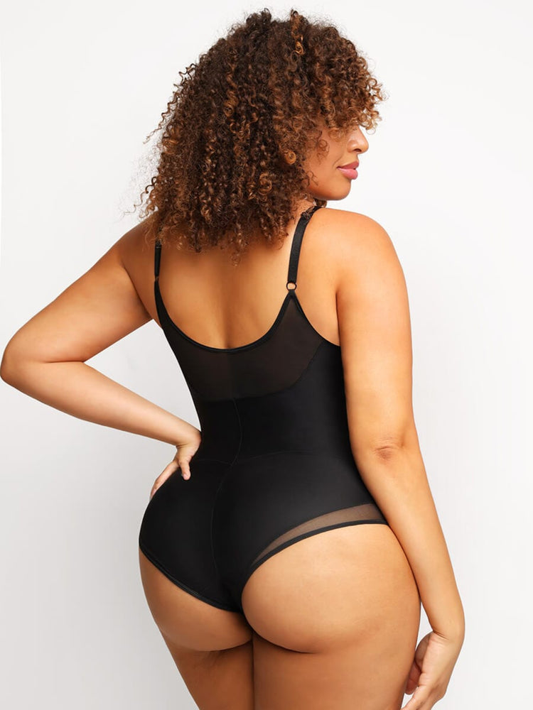 Woman wearing a black bodysuit against a plain background