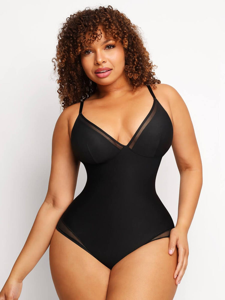 Woman wearing a black bodysuit against a plain background