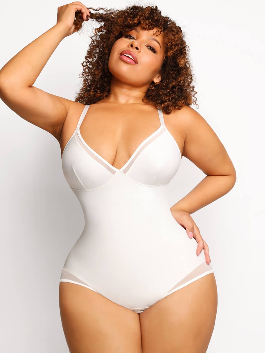 Woman wearing a white bodysuit against a plain background