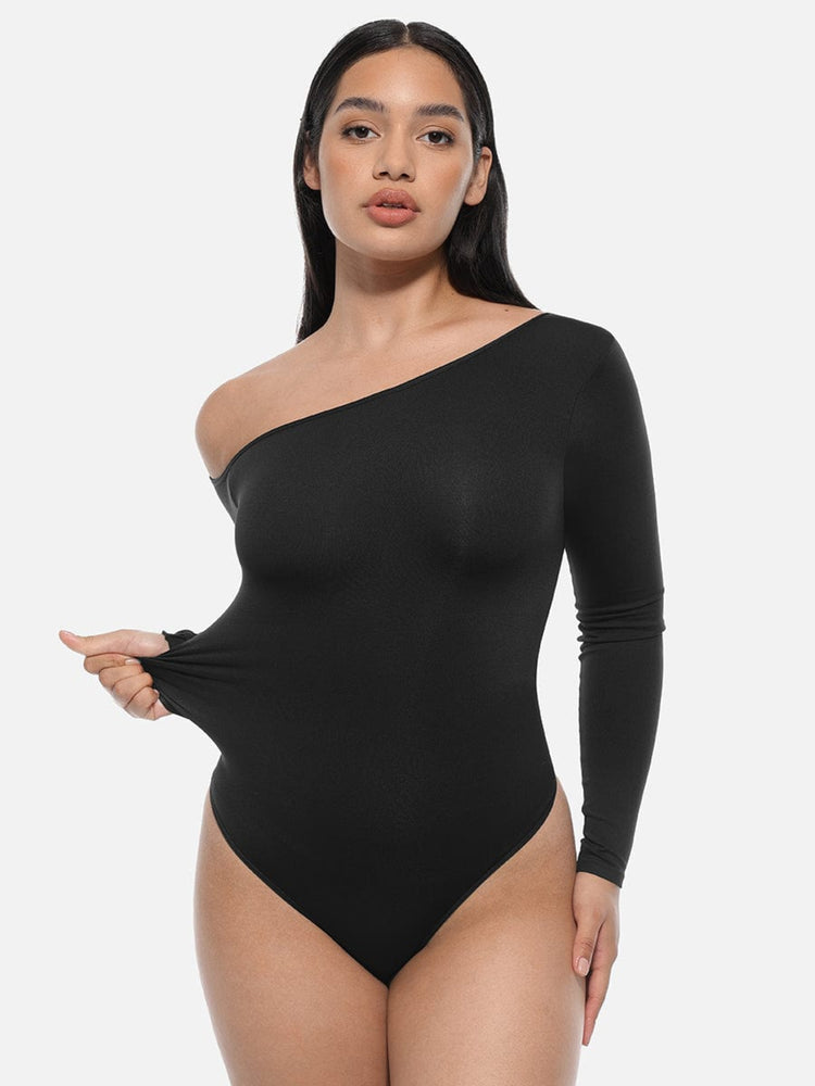 Woman wearing a black one-shoulder bodysuit on a white background