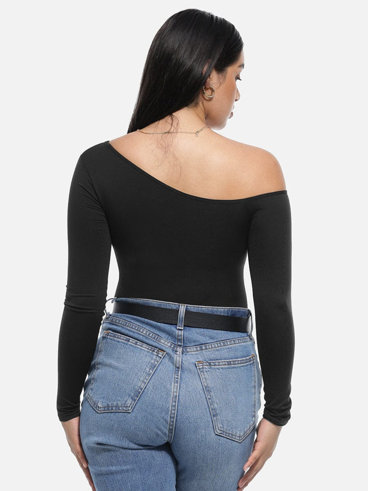 Woman wearing a black off-shoulder top and blue jeans on a white background