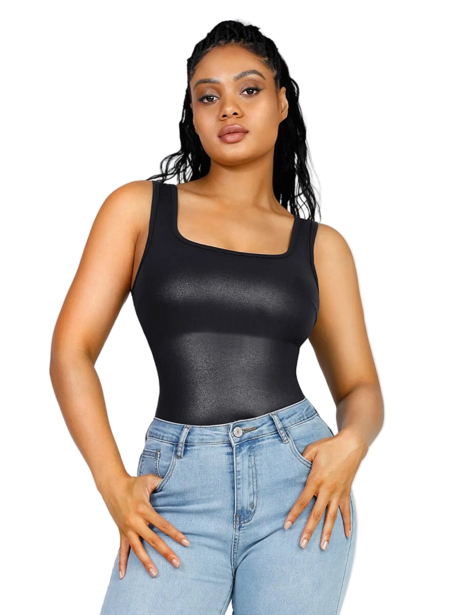 Woman wearing a black tank top and light blue jeans on a plain background