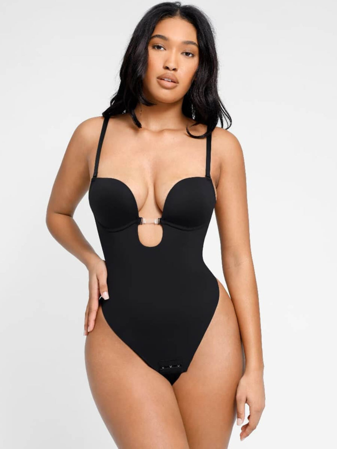 Woman wearing a black swimsuit against a white background
