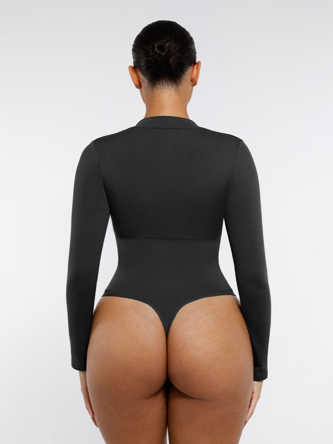 Person wearing a black bodysuit on a white background
