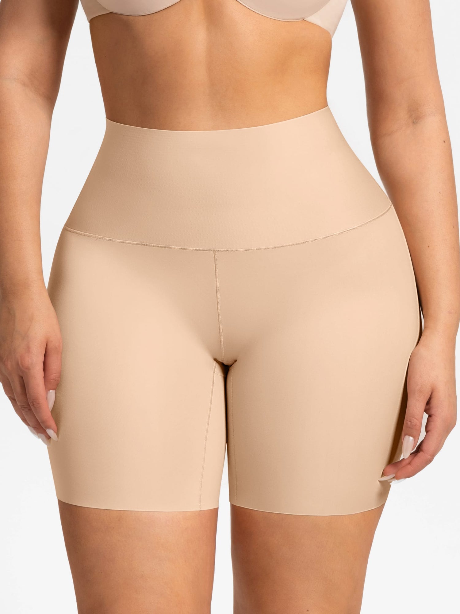 Beige high-waisted shapewear shorts worn by a model, shown from the back against a clean white background.
